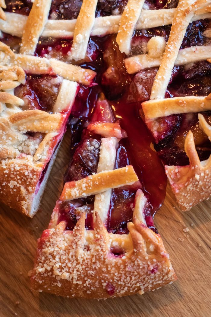 A homemade cherry pie with one slice lifted out.